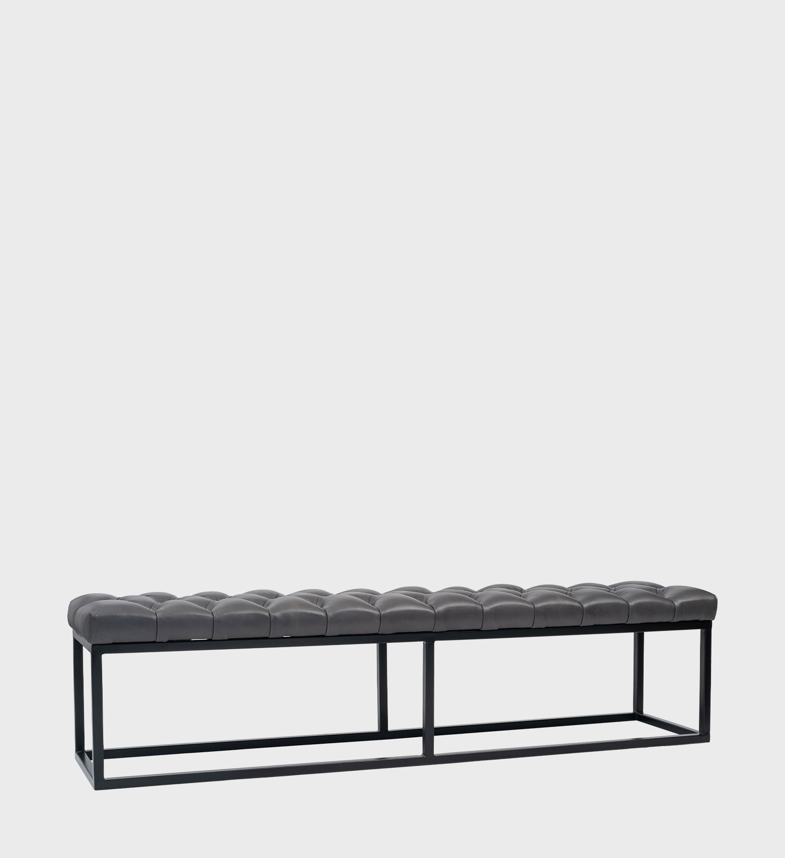 The Kelly Ottoman Steel Base blends industrial precision with refined comfort. Its tufted dark‑grey seat rests on a sleek black steel frame,