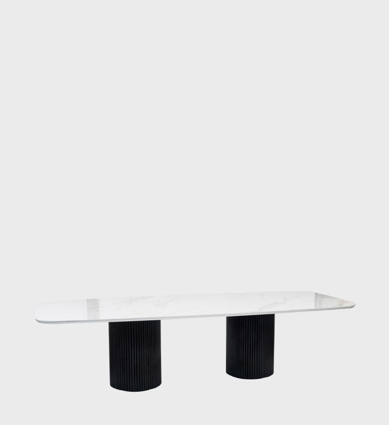 The Dolce Vita Oval Dining Table is a refined statement of modern luxury. Its smooth, marble‑effect top with soft veining rests on two cylindrical, fluted bases finished in deep black