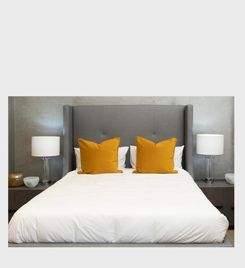 The Champagne Fully Upholstered Bed exudes contemporary elegance with its tall, button‑tufted headboard and soft grey fabric finish