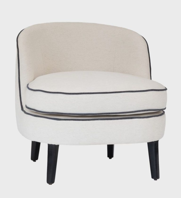 The Luca Slipper Chair embodies effortless elegance with its rounded silhouette and tailored simplicity. Upholstered in soft ivory fabric with contrasting dark piping